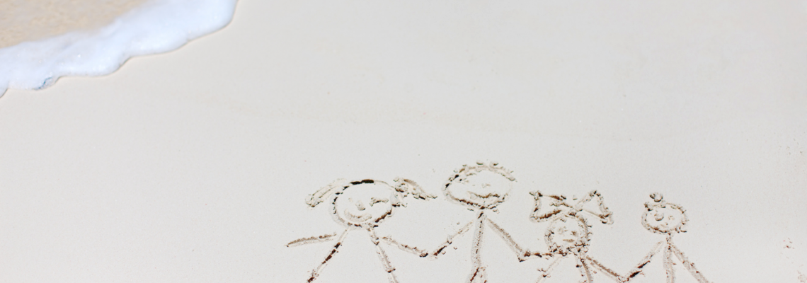 Im Sand gemalte Familie mit zwei Kindern als Strichmännchen